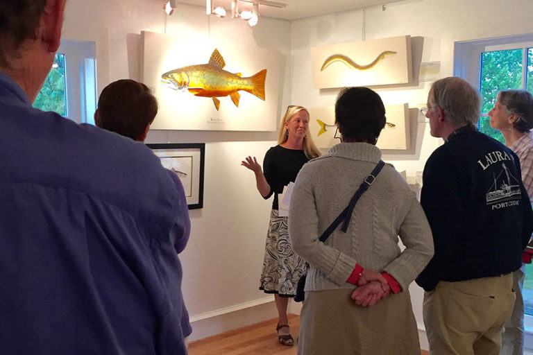 Guided talk in MCI Art Gallery by artist with scientific illustrations of fish on wall